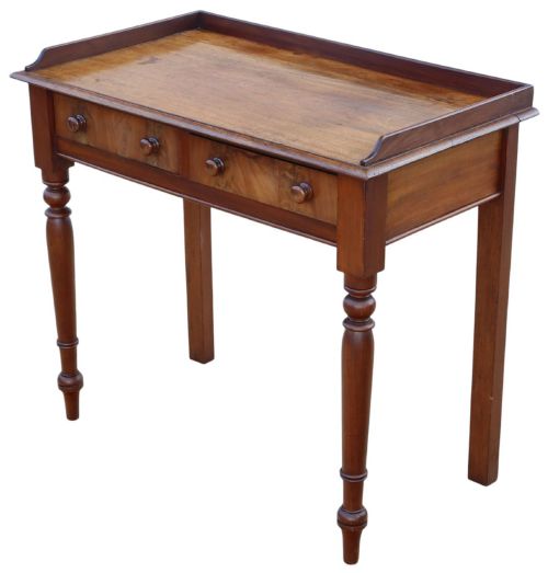 fig 3. A 19th-century mahogany writing table featuring a gallery top, two frieze drawers with wooden knob handles, and turned legs.