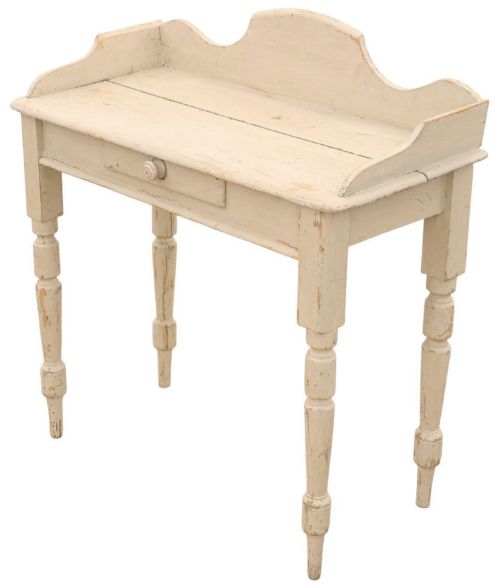 fig 1. A 19th-century cream painted wooden writing table featuring a shaped gallery back, turned legs, and a single central drawer with a turned wooden knob.