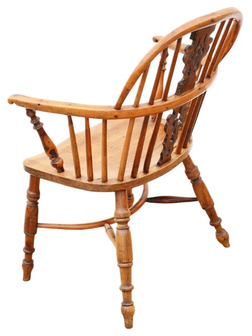 fig 2. A nineteenth-century wooden Windsor armchair featuring a curved hoop back, a decorative central splat, shaped elm seat, and turned legs with a crinoline stretcher.