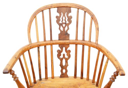 fig 3. A nineteenth-century wooden Windsor armchair featuring a curved hoop back, a decorative central splat, shaped elm seat, and turned legs with a crinoline stretcher.