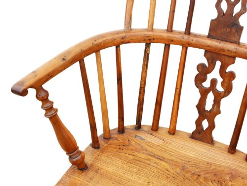 fig 5. A nineteenth-century wooden Windsor armchair featuring a curved hoop back, a decorative central splat, shaped elm seat, and turned legs with a crinoline stretcher.