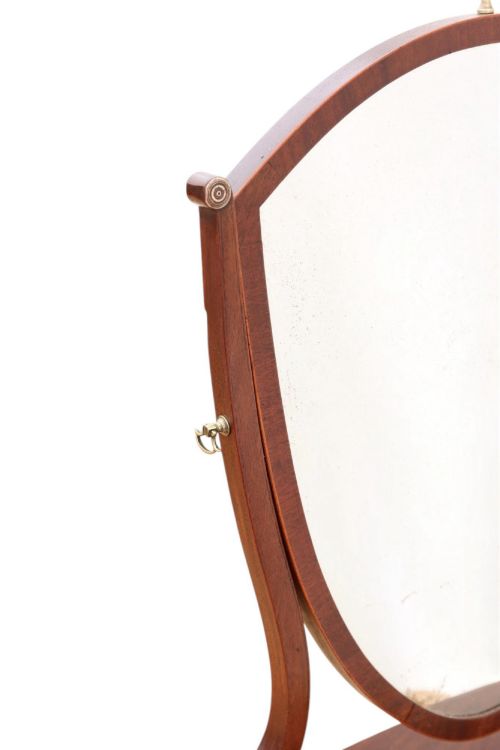 fig 1. A 19th-century Georgian mahogany swing mirror featuring a shield-shaped frame supported by curved uprights over a shaped base with three small drawers.