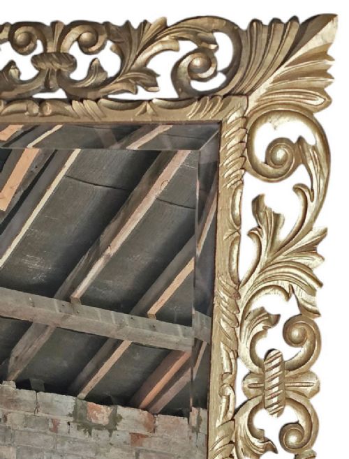 fig 3. A rectangular bevelled glass mirror set within an intricately carved gold giltwood frame with openwork acanthus leaves and scrollwork.