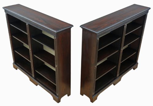 fig 2. A matching pair of dark oak double-bay bookcases featuring fluted vertical trim, adjustable shelving, green pattern-lined interiors, and bracket bases.