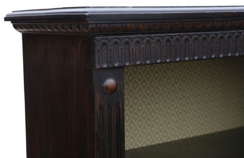 fig 4. A matching pair of dark oak double-bay bookcases featuring fluted vertical trim, adjustable shelving, green pattern-lined interiors, and bracket bases.