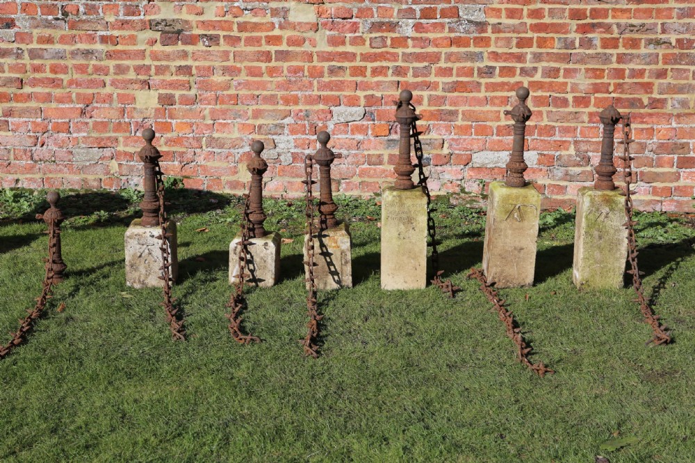 Set of 7 cast iron bollards with stone bases