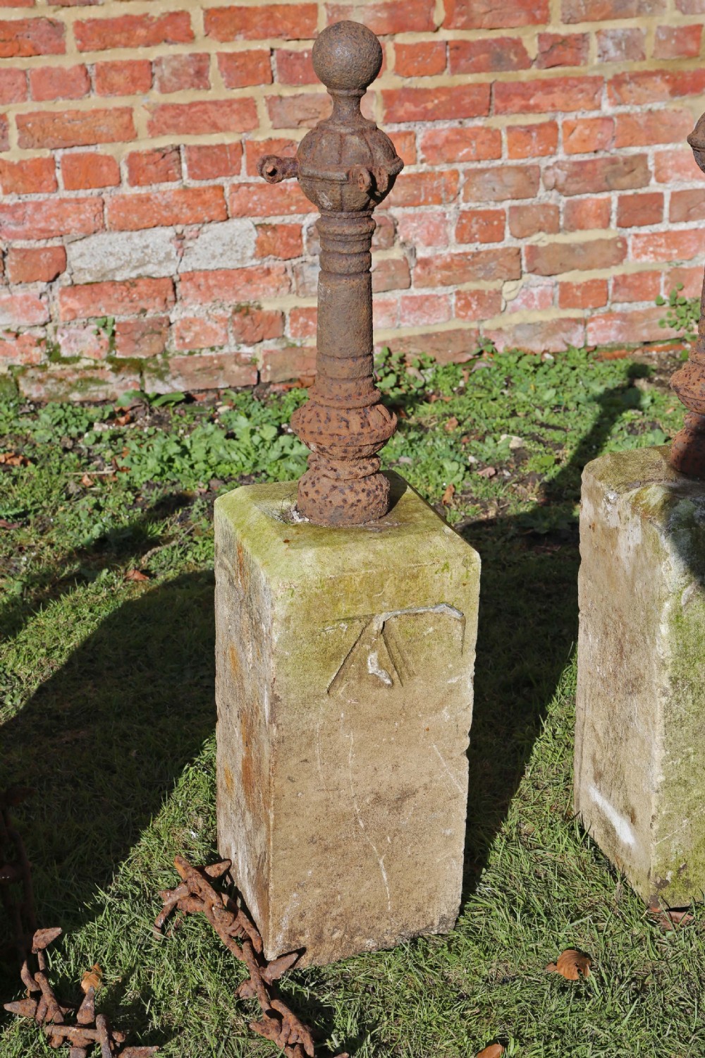 Set of 7 cast iron bollards with stone bases View V