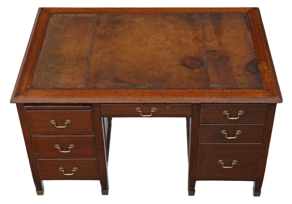 A mahogany twin pedestal writing desk featuring a worn brown leather top insert, multiple drawers with brass handles, and square tapered feet. View III
