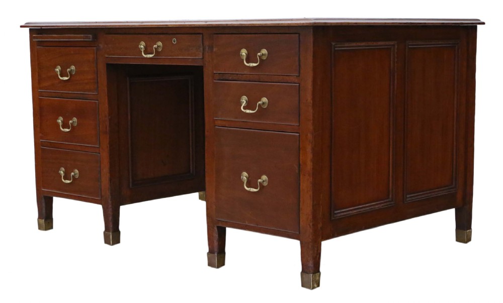 A mahogany twin pedestal writing desk featuring a worn brown leather top insert, multiple drawers with brass handles, and square tapered feet. View X