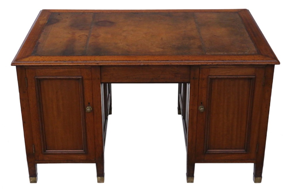 A mahogany twin pedestal writing desk featuring a worn brown leather top insert, multiple drawers with brass handles, and square tapered feet. View XII