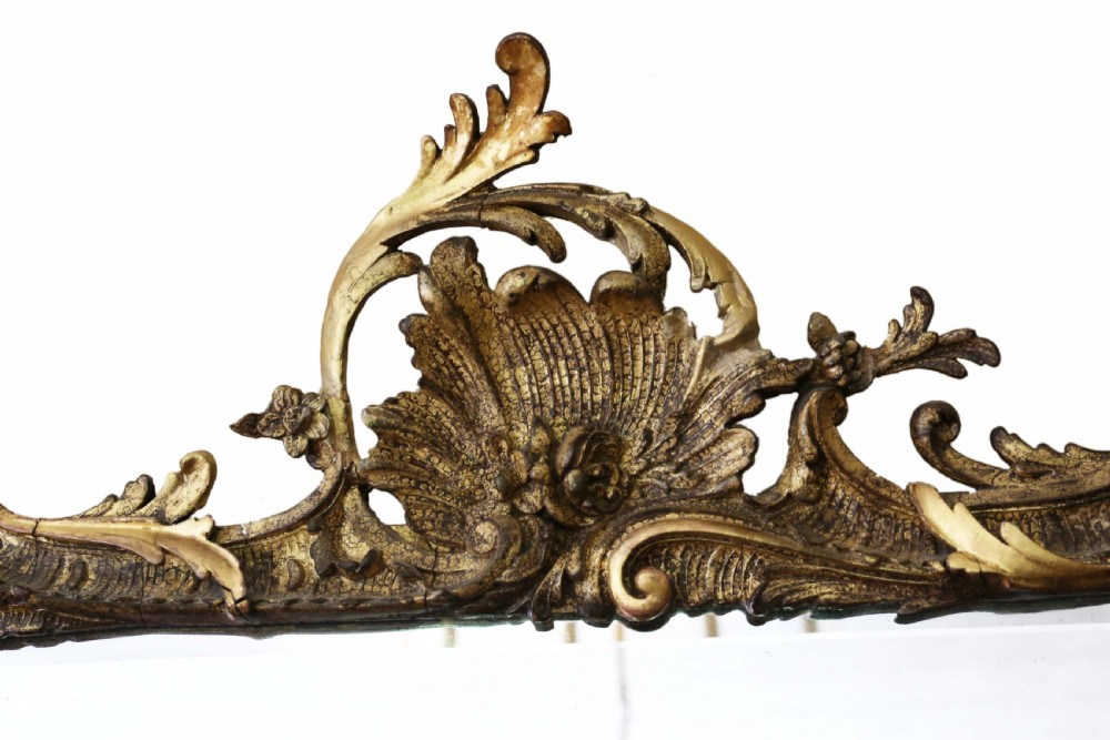 An ornate early 19th-century Rococo Revival style rectangular giltwood wall mirror featuring elaborate scrolling acanthus leaf carvings and a central shell cresting. View II