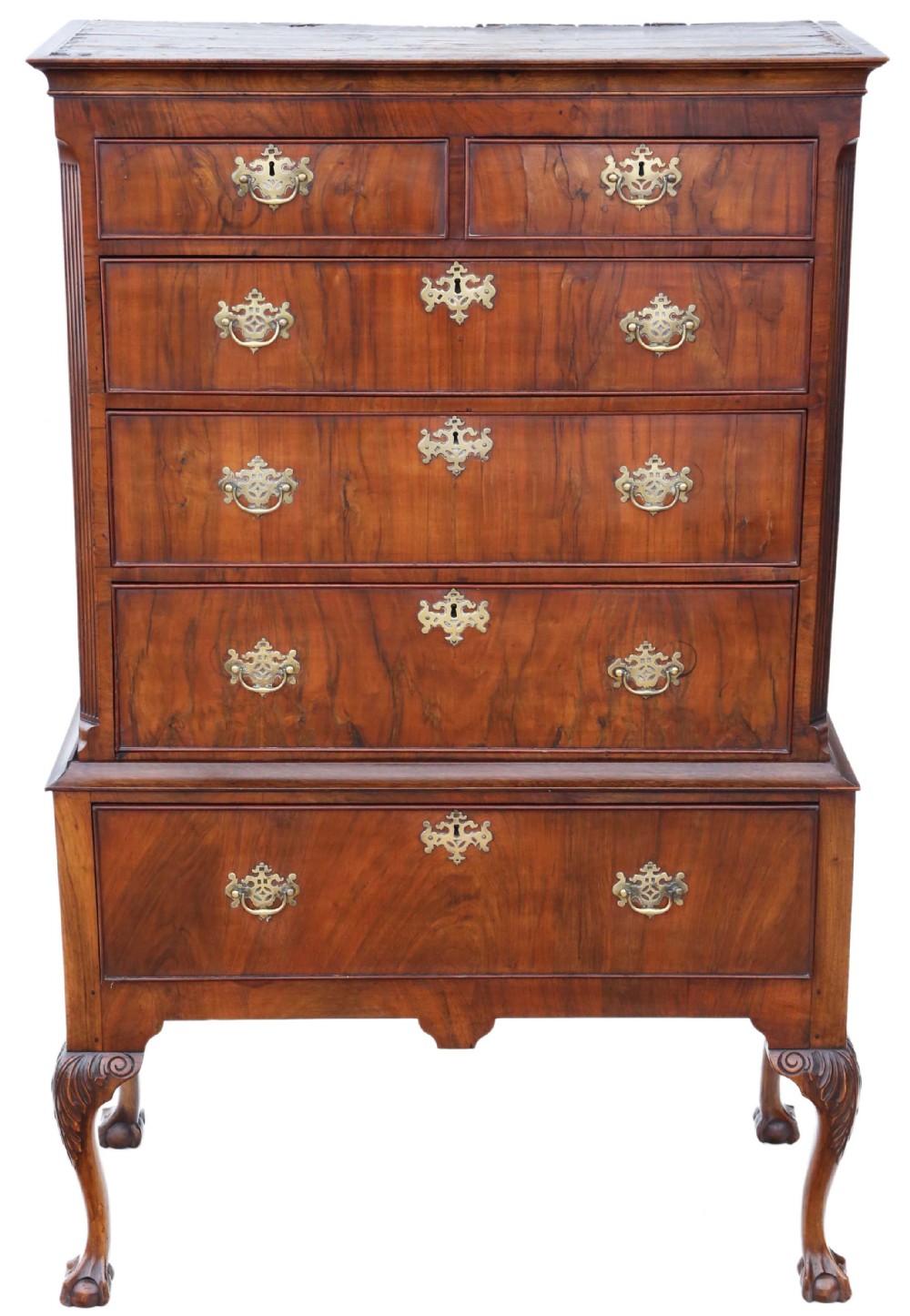 A Georgian figured walnut chest of drawers featuring ornate brass handles and escutcheons, set on cabriole legs with carved claw and ball feet.