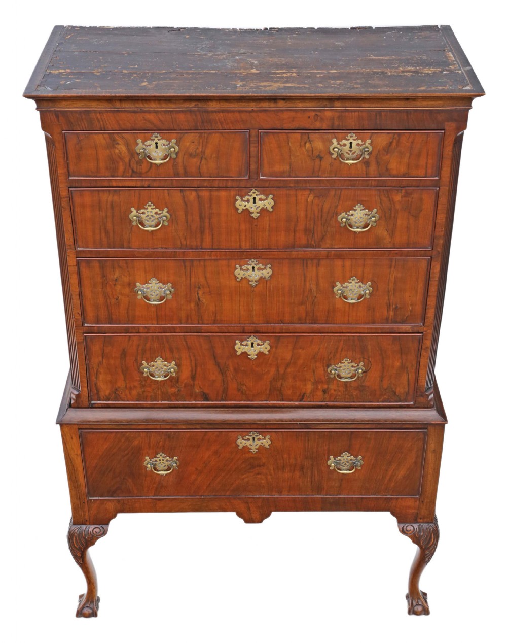 A Georgian figured walnut chest of drawers featuring ornate brass handles and escutcheons, set on cabriole legs with carved claw and ball feet. View V