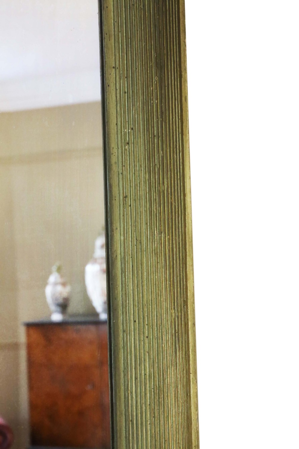 A large rectangular wall mirror featuring a linear reeded gilt wood frame. View II