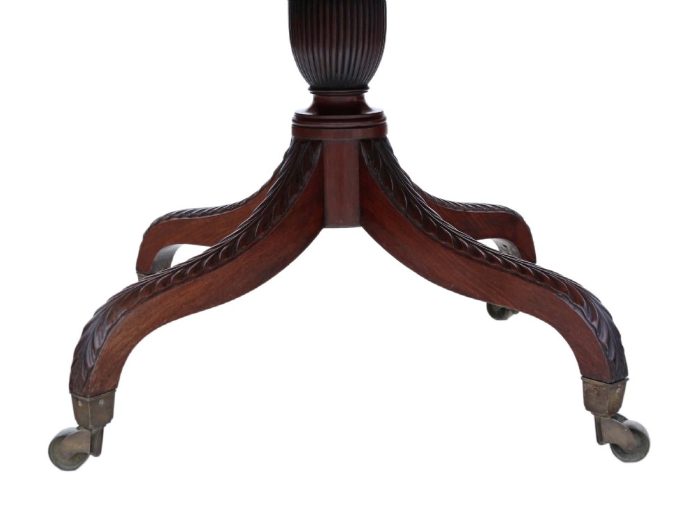 A Regency period Cuban mahogany drop leaf dining table extended with a central pedestal and four reeded splayed legs on brass castors. View VI