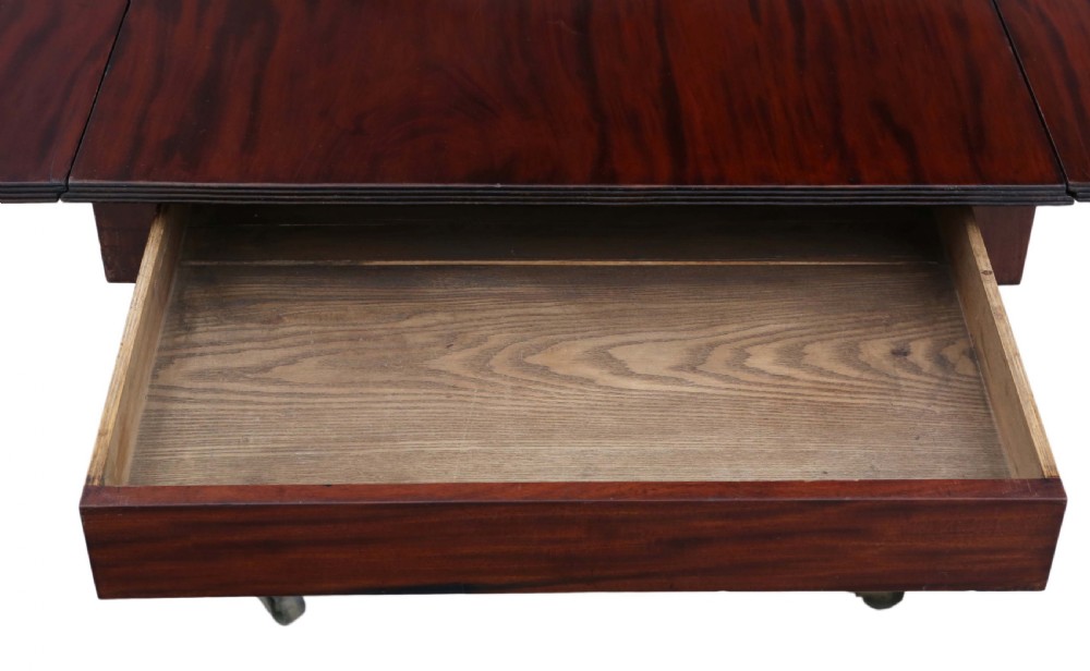 A Regency period Cuban mahogany drop leaf dining table extended with a central pedestal and four reeded splayed legs on brass castors. View IX
