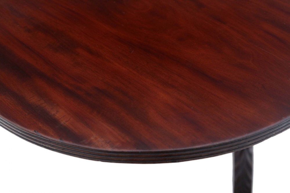A Regency period Cuban mahogany drop leaf dining table extended with a central pedestal and four reeded splayed legs on brass castors. View XII