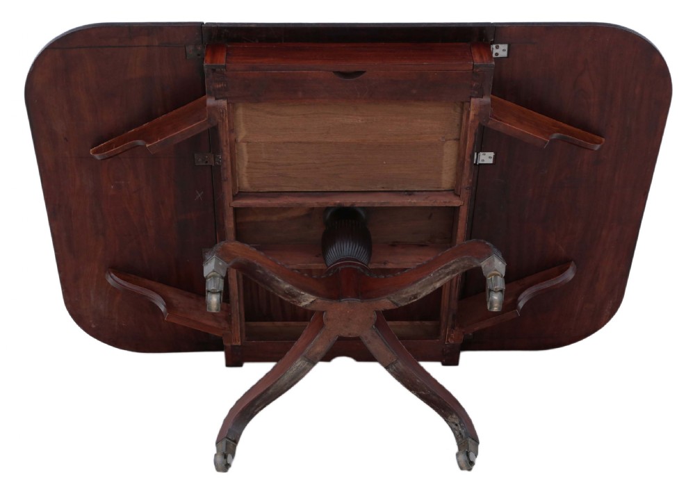 A Regency period Cuban mahogany drop leaf dining table extended with a central pedestal and four reeded splayed legs on brass castors. View XIII