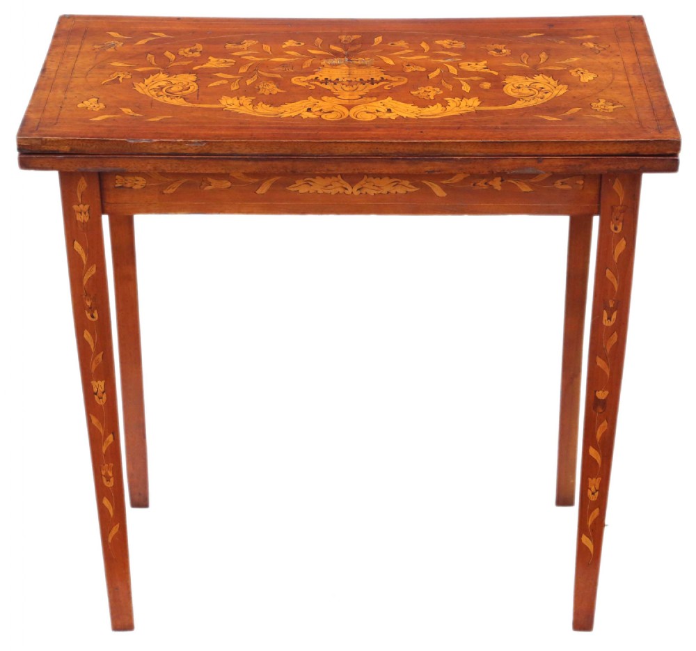 A Victorian mahogany fold-over card table decorated with central urn floral marquetry inlays on the top and tapered legs.