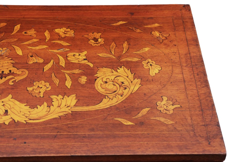 A Victorian mahogany fold-over card table decorated with central urn floral marquetry inlays on the top and tapered legs. View V