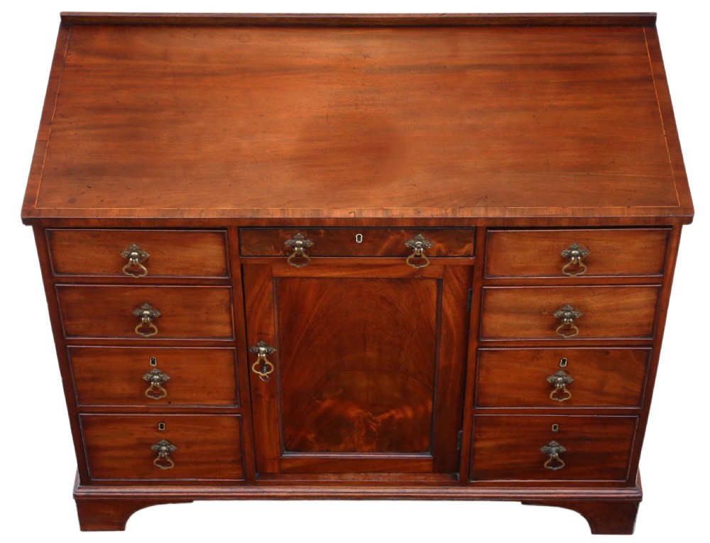 A late Georgian mahogany kneehole desk circa 1820 featuring a central recessed cupboard, eight side drawers with brass swing handles, and bracket feet. View III