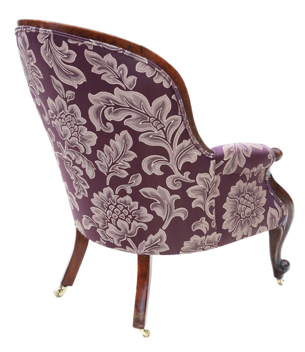 A Victorian mahogany spoon back armchair upholstered in deep purple damask fabric with deep buttoning and cabriole legs. View V