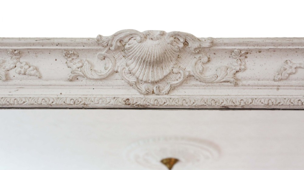 A large rectangular overmantel mirror featuring an off-white carved gesso frame decorated with scallop shell motifs, foliage, and corner crests. View VI