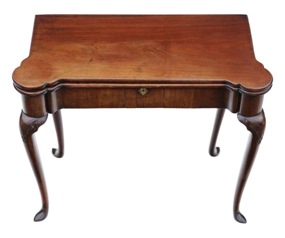 A Georgian mahogany folding card table featuring a shaped serpentine top, a single brass keyhole escutcheon, and four slender cabriole legs ending in pad feet. View II