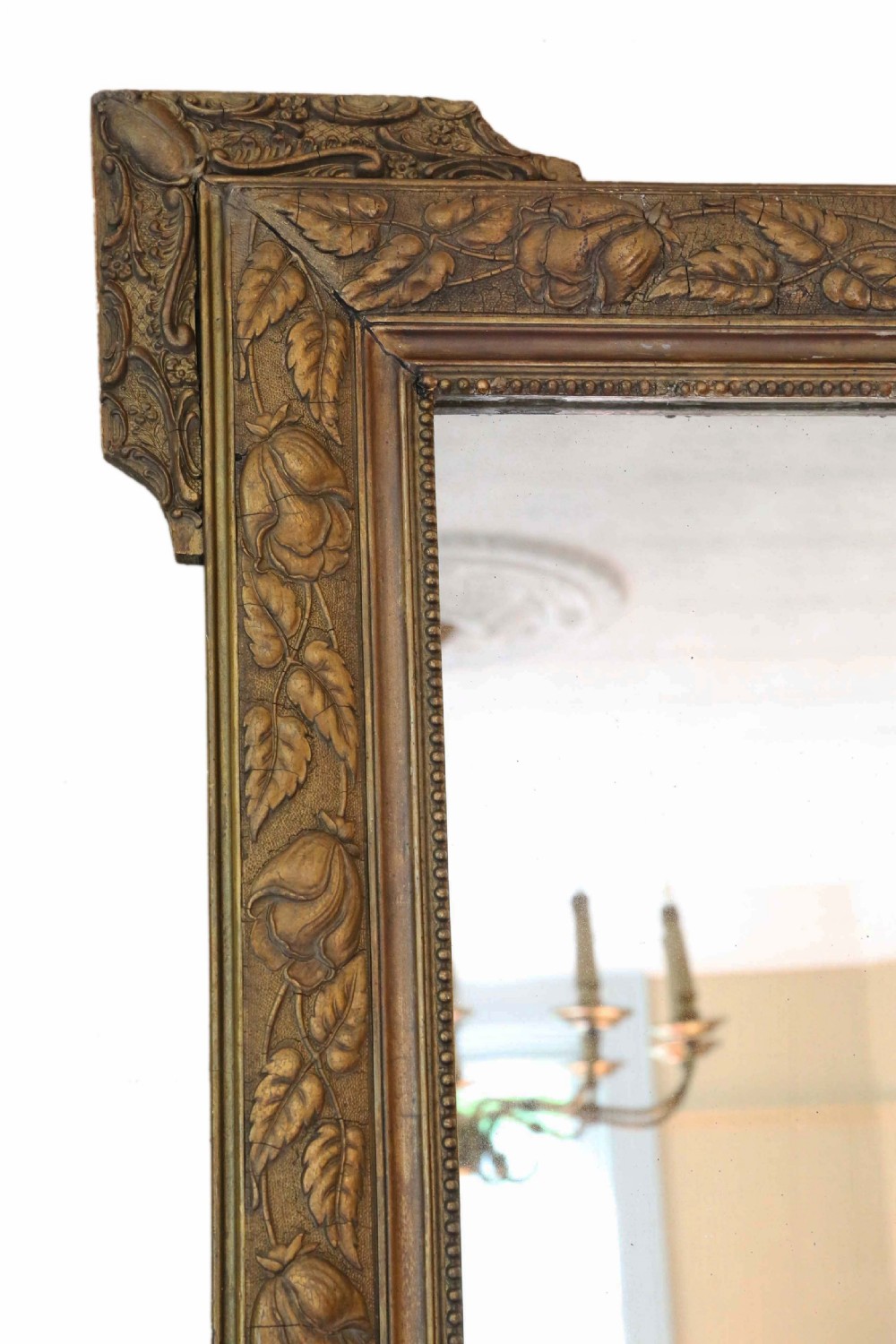 A large rectangular 19th-century giltwood mirror with foliate relief mouldings and corner ear projections. View II