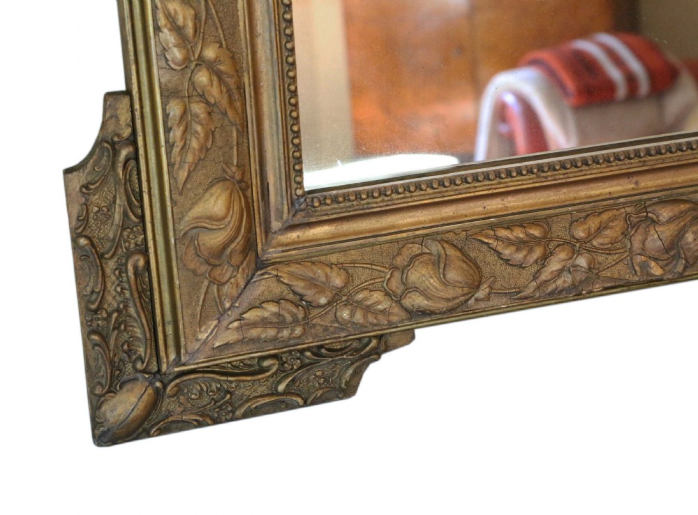 A large rectangular 19th-century giltwood mirror with foliate relief mouldings and corner ear projections. View V