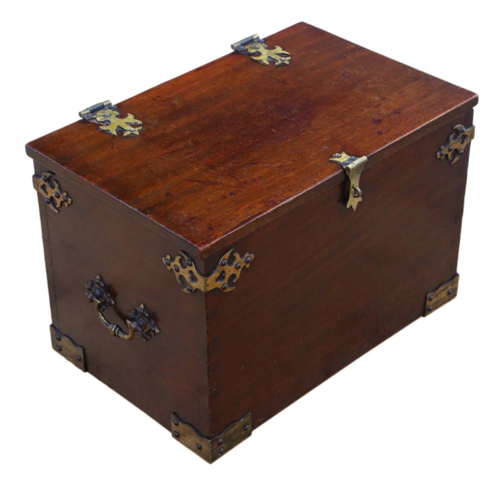 A rectangular mahogany wooden box featuring decorative brass corner mounts, top strap hinges, and a central brass clasp mechanism. View VI