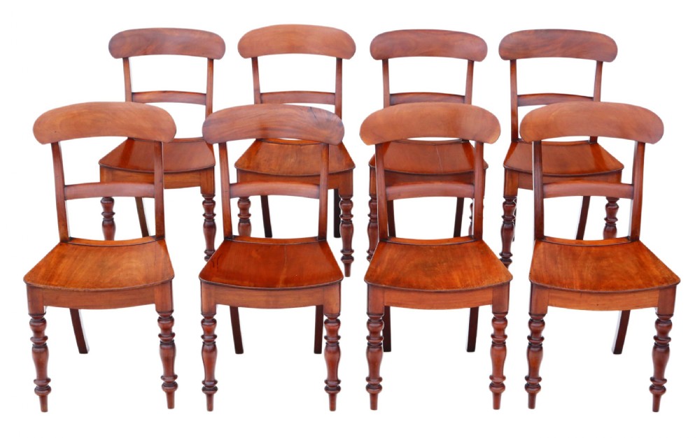 A matched set of eight antique Victorian mahogany dining chairs featuring curved top rails, solid wood seats, and turned front legs.