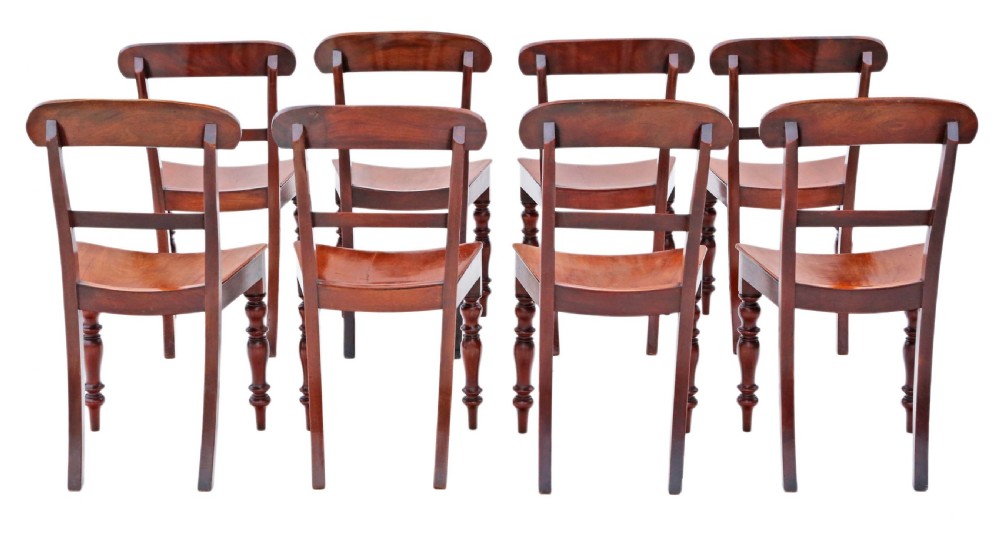 A matched set of eight antique Victorian mahogany dining chairs featuring curved top rails, solid wood seats, and turned front legs. View II