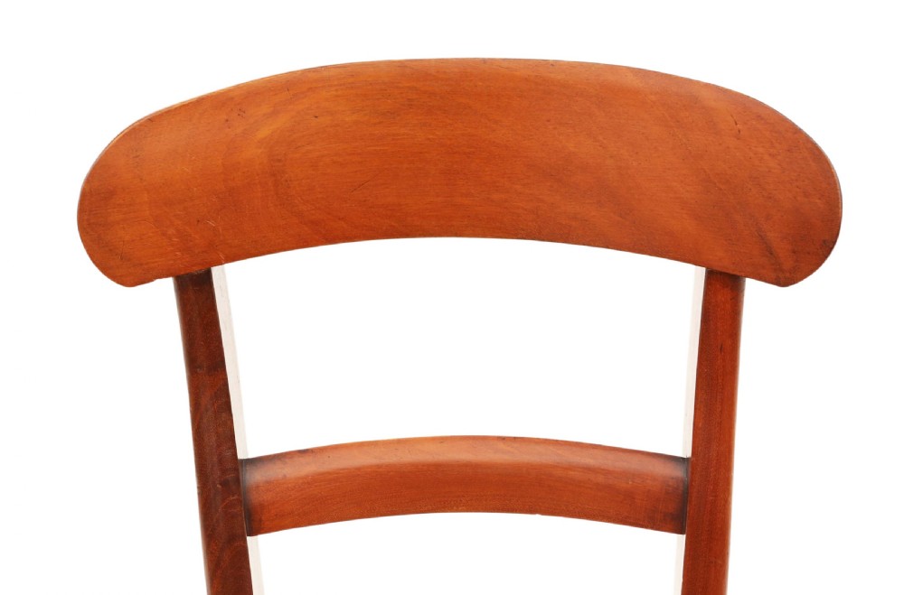 A matched set of eight antique Victorian mahogany dining chairs featuring curved top rails, solid wood seats, and turned front legs. View VIII