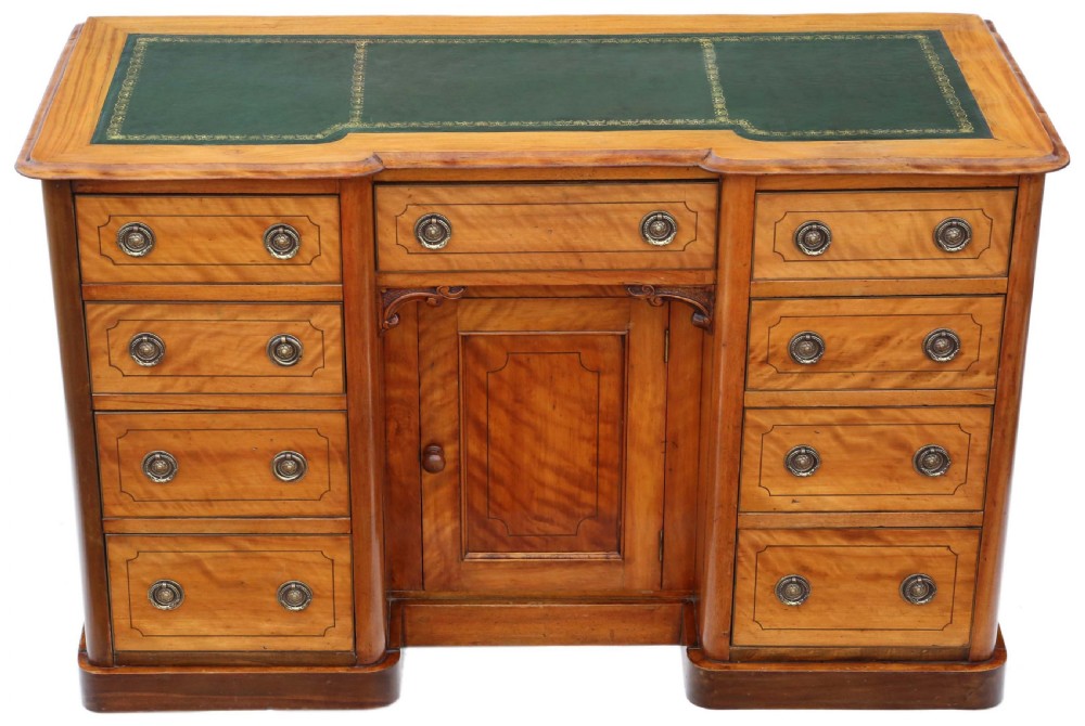 A Victorian satin walnut pedestal desk featuring a green gilt-tooled leather writing surface, multiple drawers with drop ring handles, and a central cupboard door.