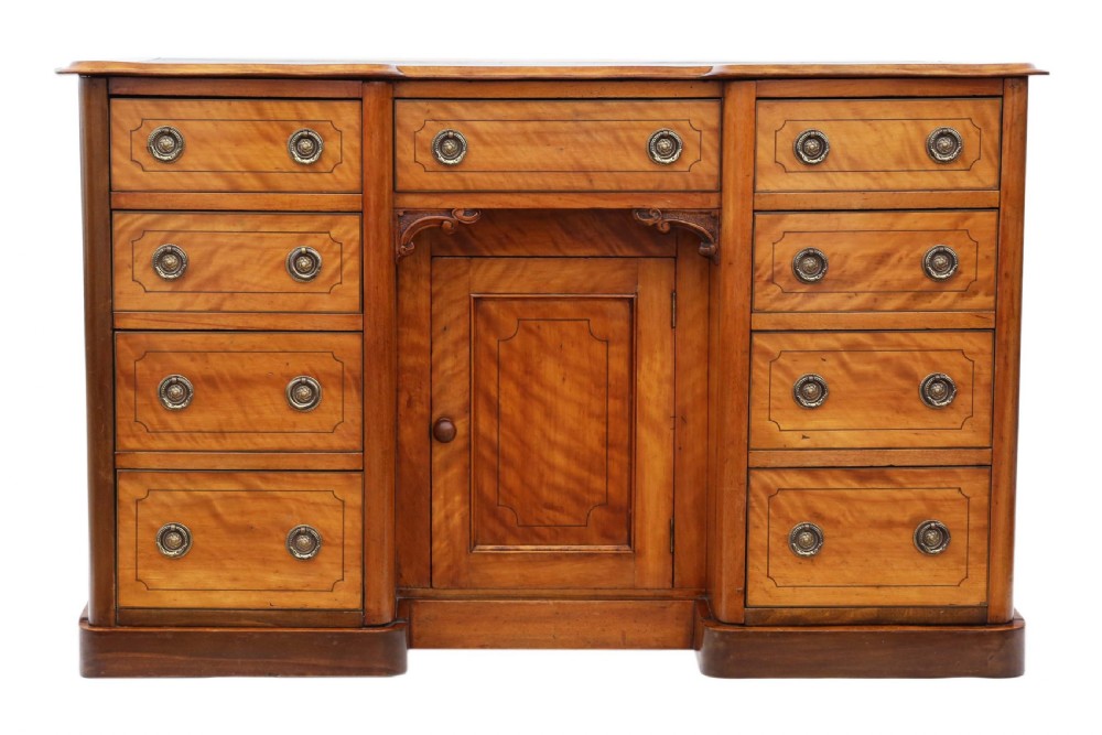 A Victorian satin walnut pedestal desk featuring a green gilt-tooled leather writing surface, multiple drawers with drop ring handles, and a central cupboard door. View III
