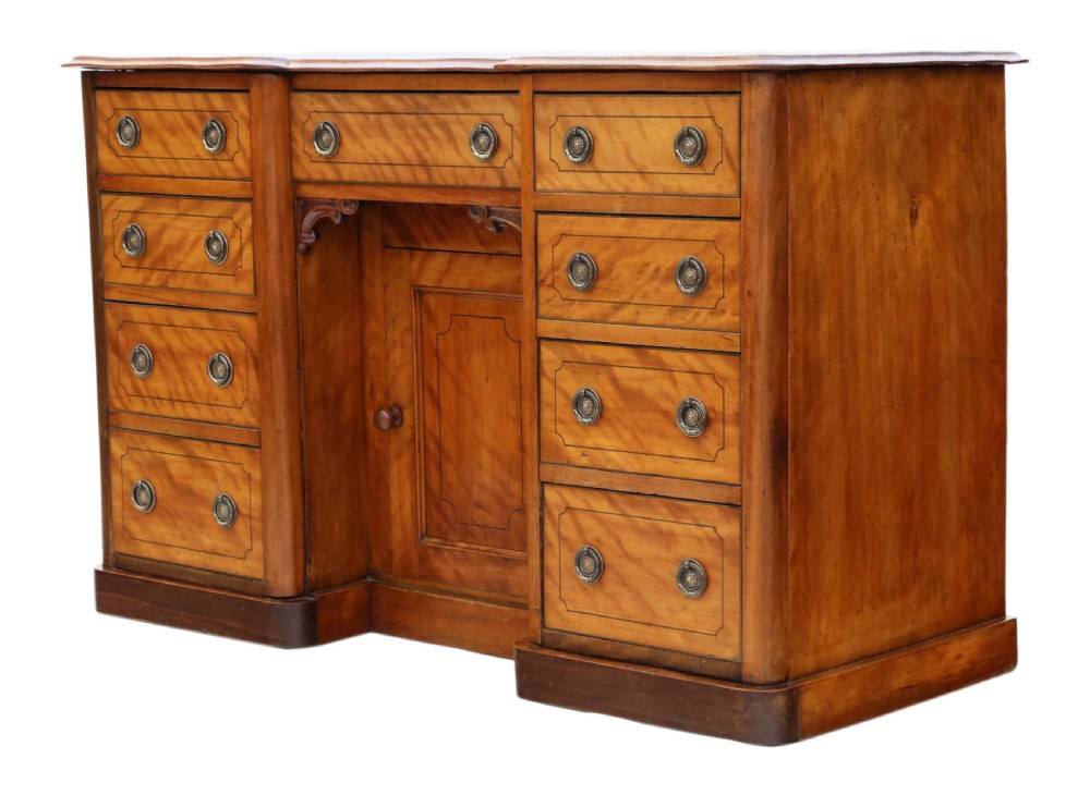 A Victorian satin walnut pedestal desk featuring a green gilt-tooled leather writing surface, multiple drawers with drop ring handles, and a central cupboard door. View V