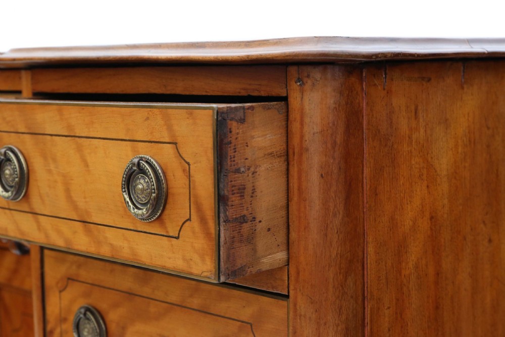 A Victorian satin walnut pedestal desk featuring a green gilt-tooled leather writing surface, multiple drawers with drop ring handles, and a central cupboard door. View VI