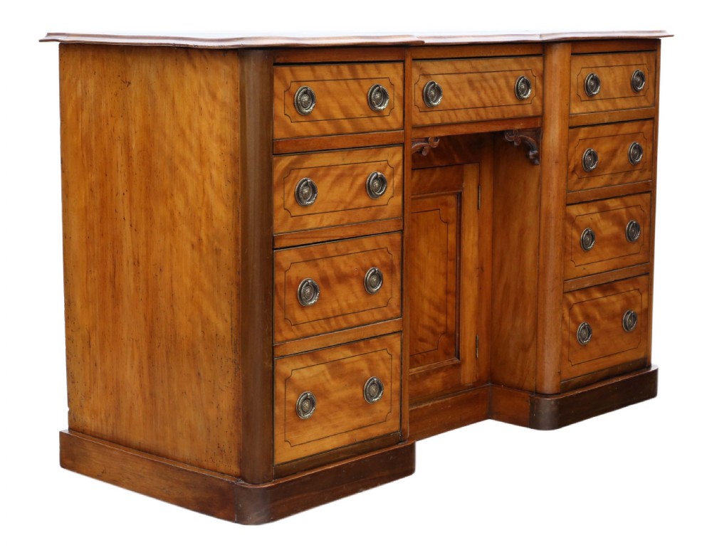 A Victorian satin walnut pedestal desk featuring a green gilt-tooled leather writing surface, multiple drawers with drop ring handles, and a central cupboard door. View VII