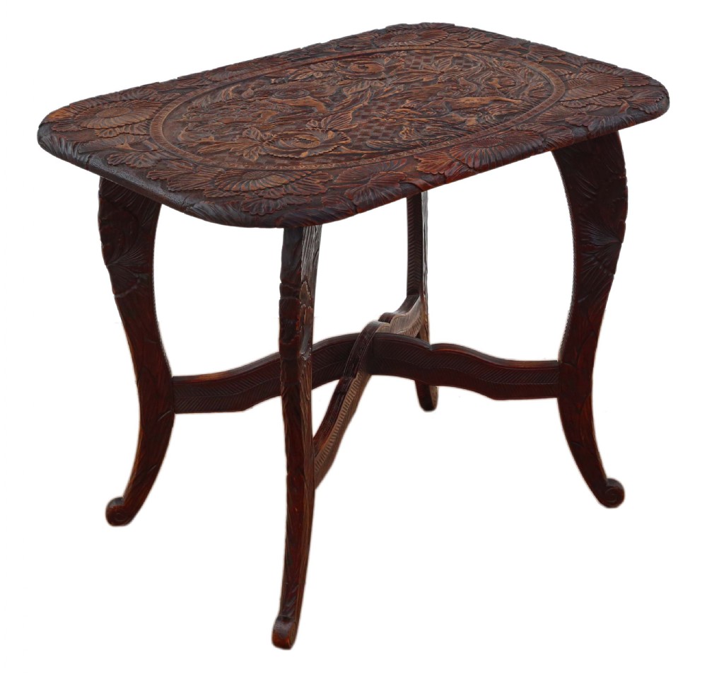 A dark carved hardwood table featuring detailed relief carvings of floral patterns on the top, curved cabriole legs, and an X-shaped stretcher. View VIII