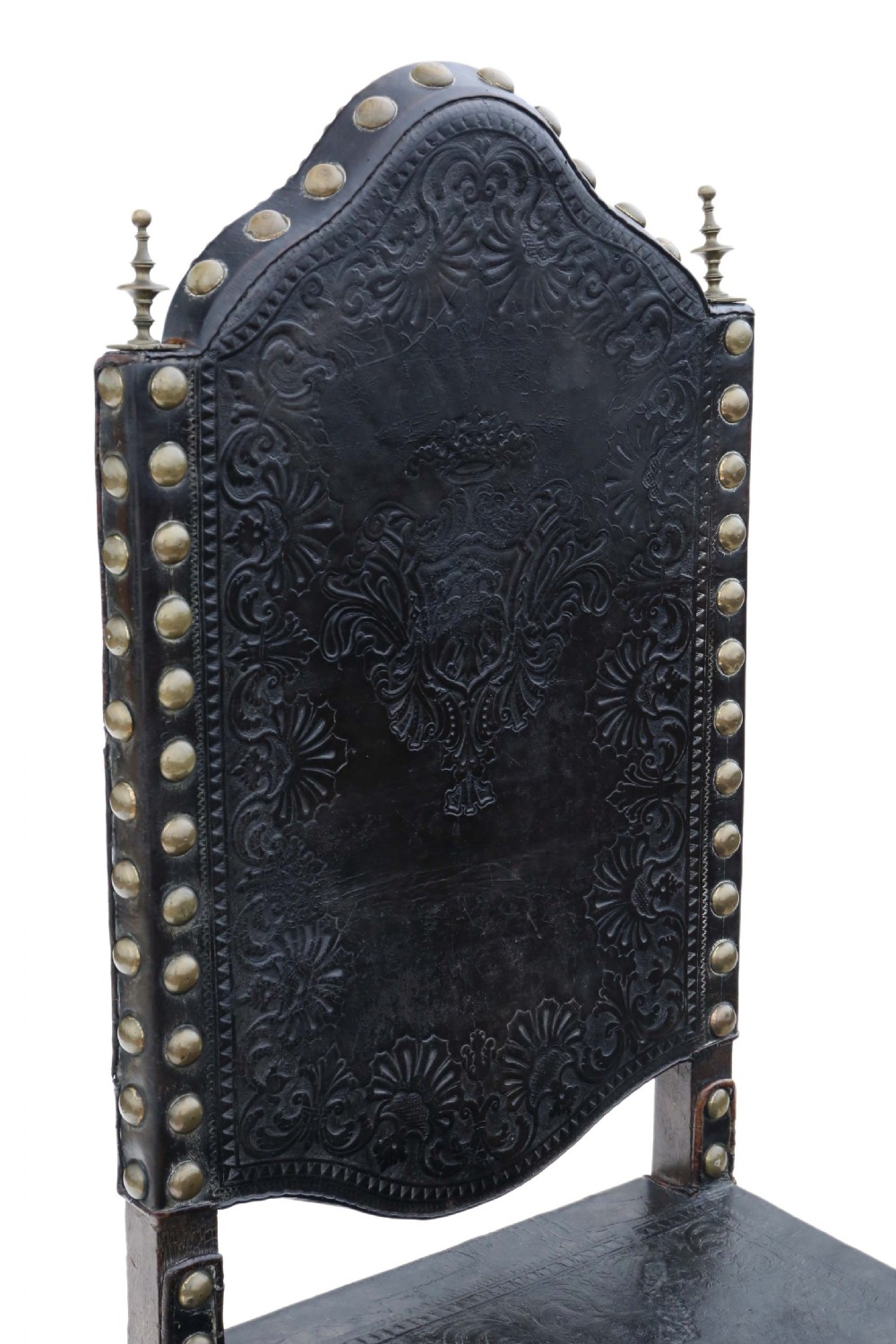 An antique Portuguese oak side chair featuring dark embossed leather upholstery with large brass studs and a carved lower stretcher. View V