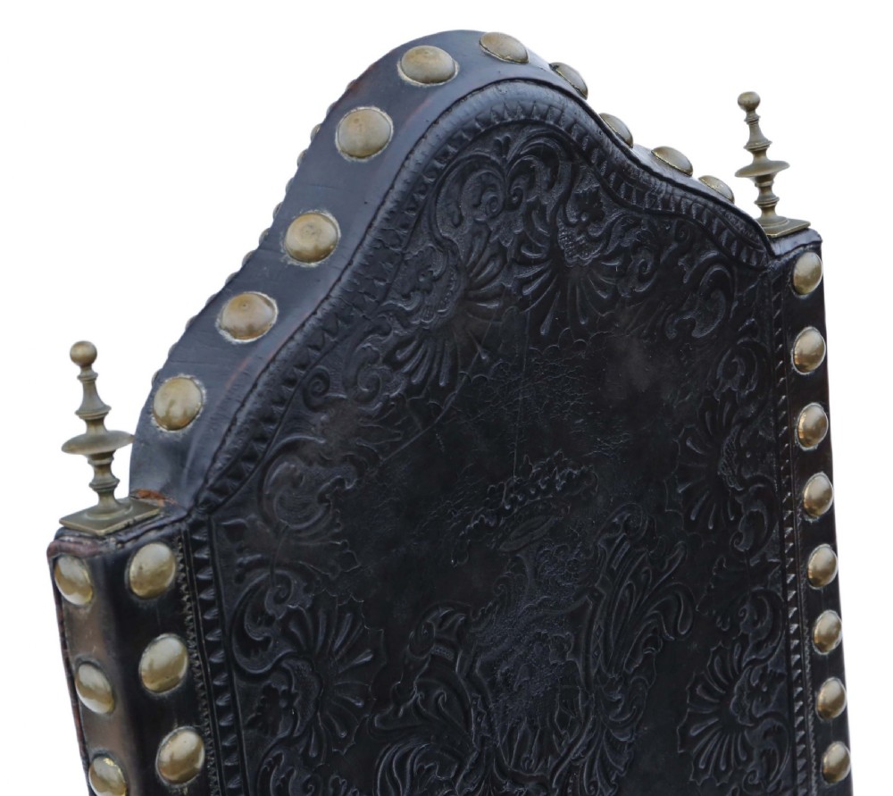An antique Portuguese oak side chair featuring dark embossed leather upholstery with large brass studs and a carved lower stretcher. View VII