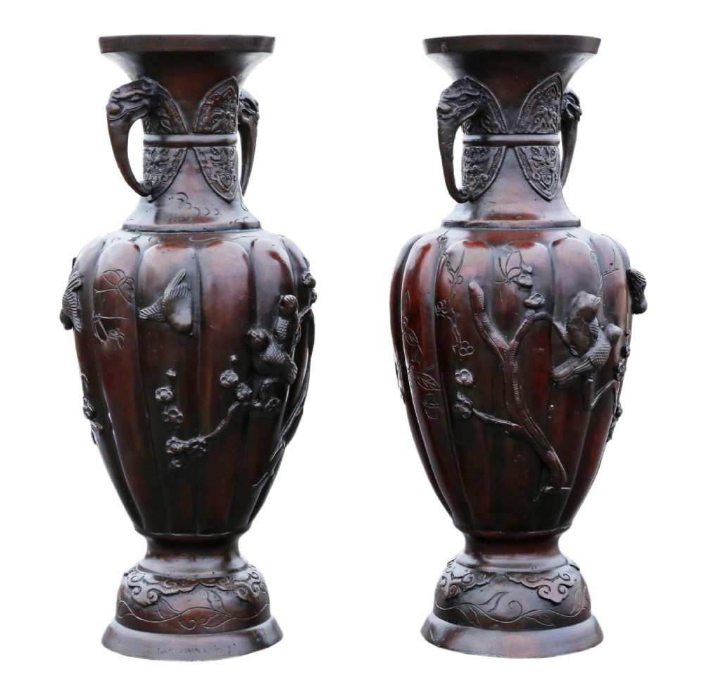 A pair of dark patinated bronze baluster vases featuring relief carvings of birds on branches and elephant head handles. View II