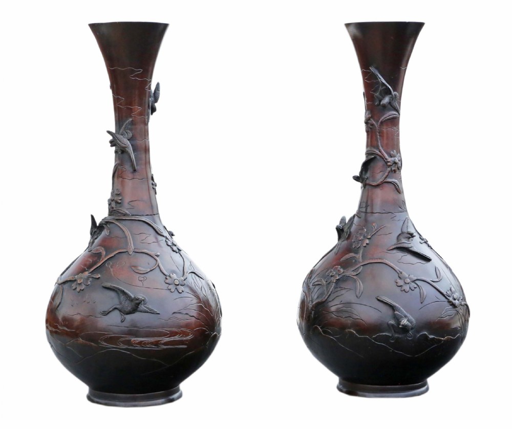 A pair of large Japanese bronze baluster vases featuring relief decoration of birds amidst flowering branches against a dark brown patinated finish. View II