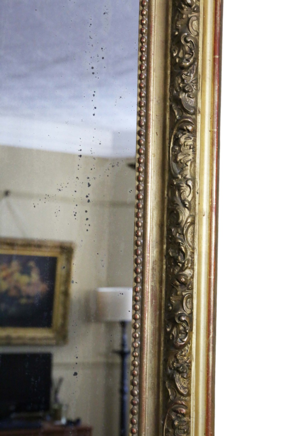 A tall 19th-century arched giltwood overmantel mirror featuring an ornate carved shell crest and decorative moulded frame. View V