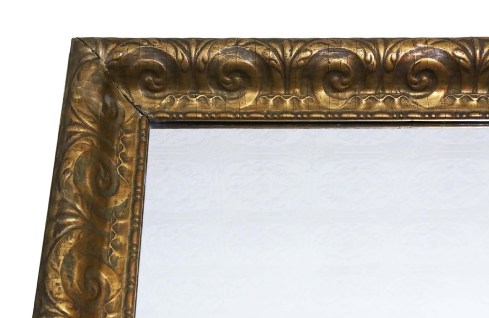A large rectangular 19th-century overmantel mirror featuring a thick gold giltwood frame carved with continuous scroll motifs. View II