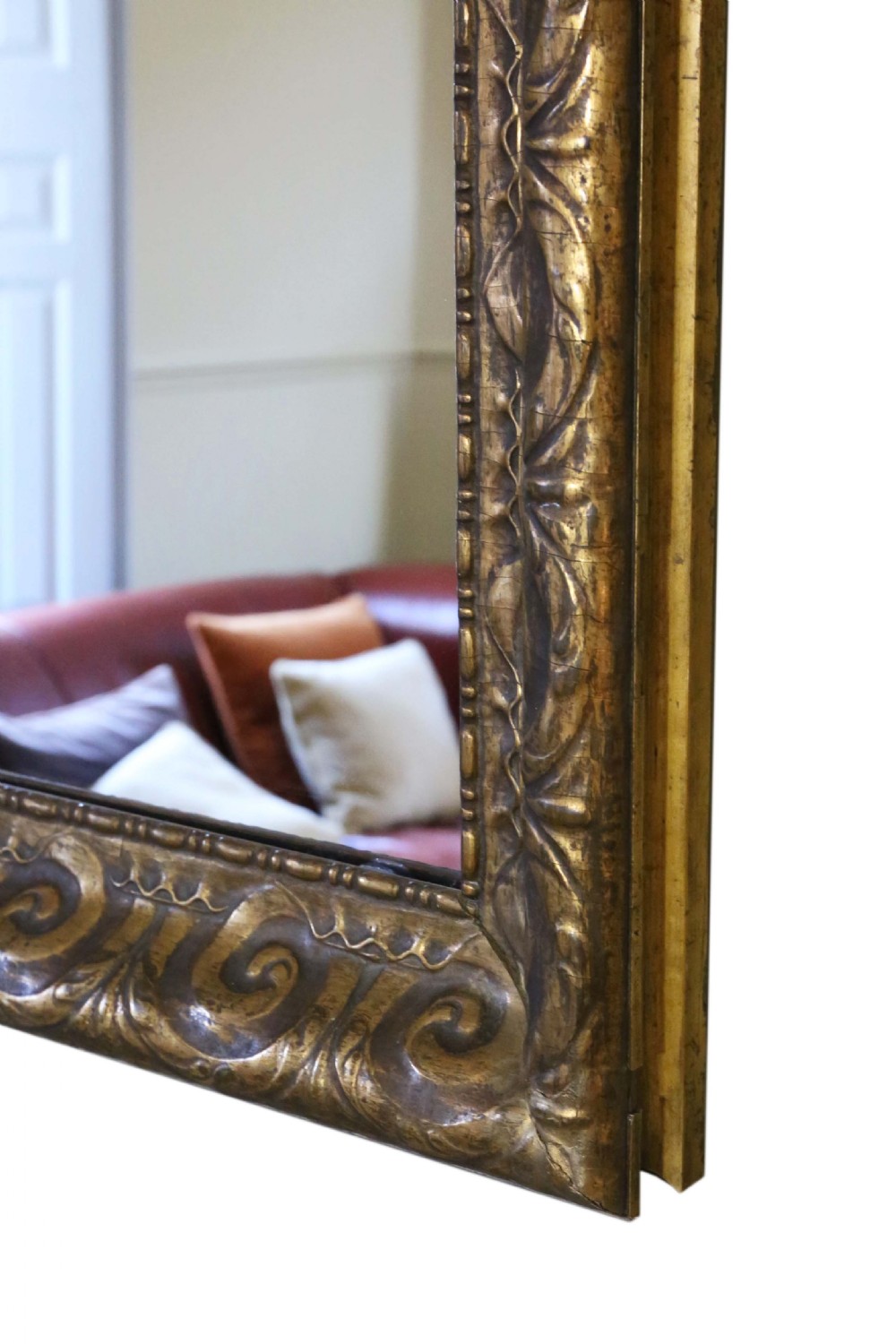 A large rectangular 19th-century overmantel mirror featuring a thick gold giltwood frame carved with continuous scroll motifs. View V