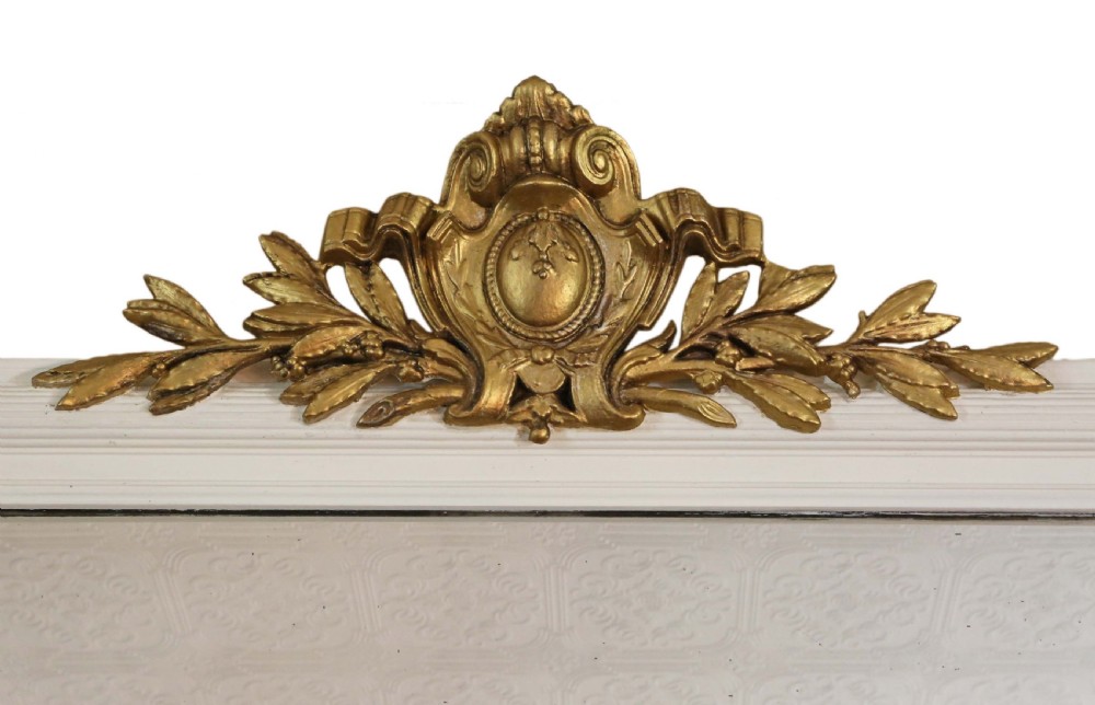 A large 19th-century rectangular wall mirror featuring a painted white frame topped with an ornate gilded crest. View II