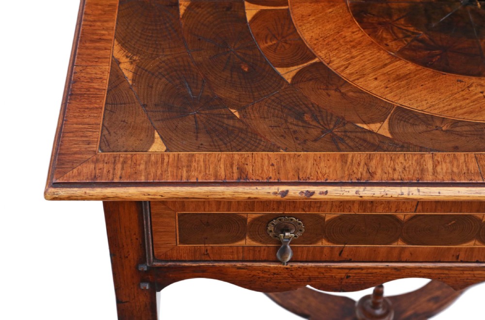 A Queen Anne revival walnut side table featuring a circular oyster veneer top pattern, a single drawer with brass handles, turned legs, and an X-stretcher. View VI