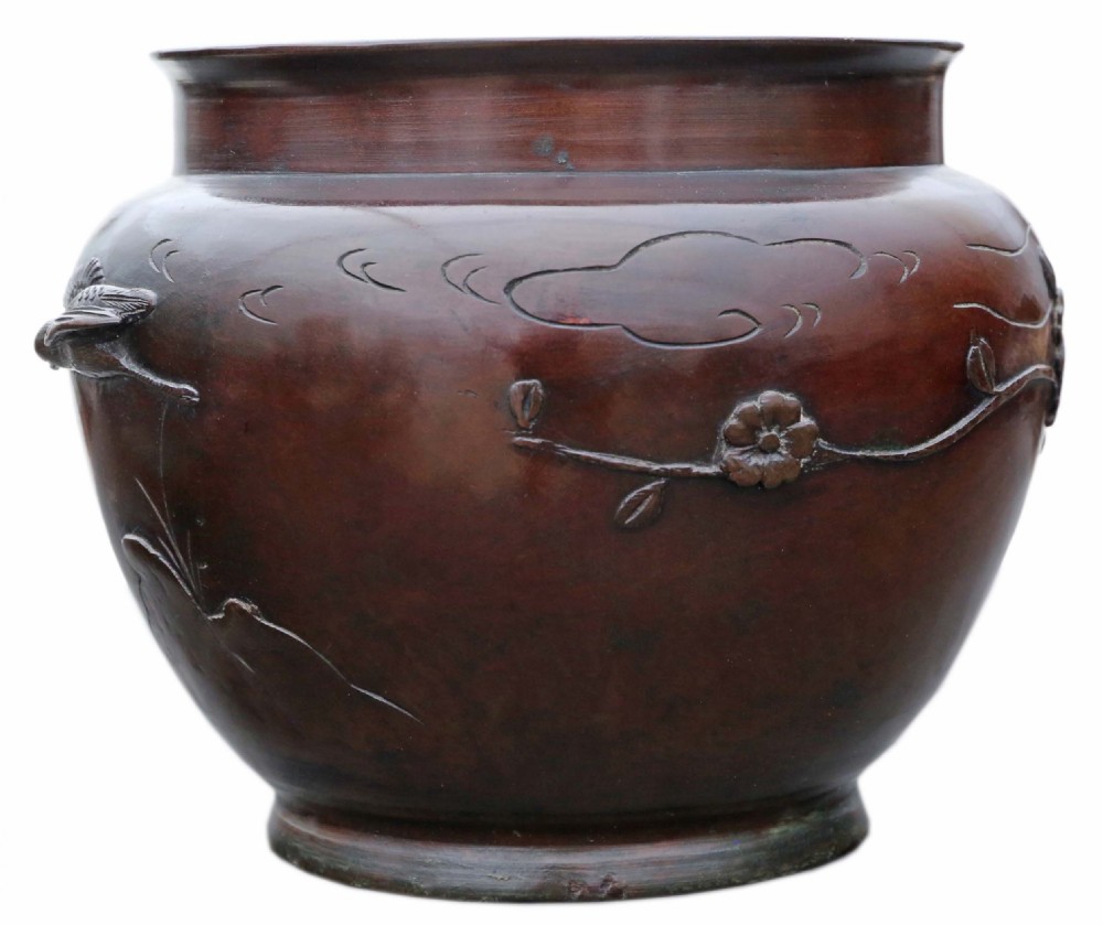 A dark brown bronze Japanese Meiji period jardiniere with high-relief castings of birds resting on prunus branches. View II